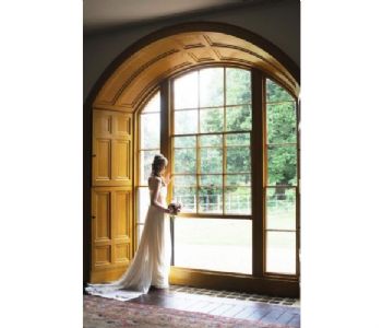 Bride by window at Moggerhanger